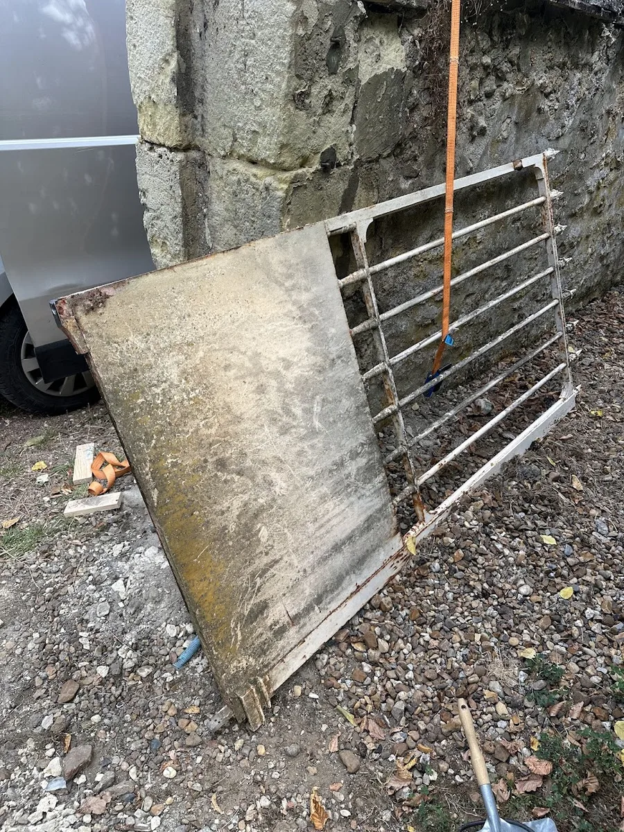 Les deux vantaux du portail déposés contre le mur du château